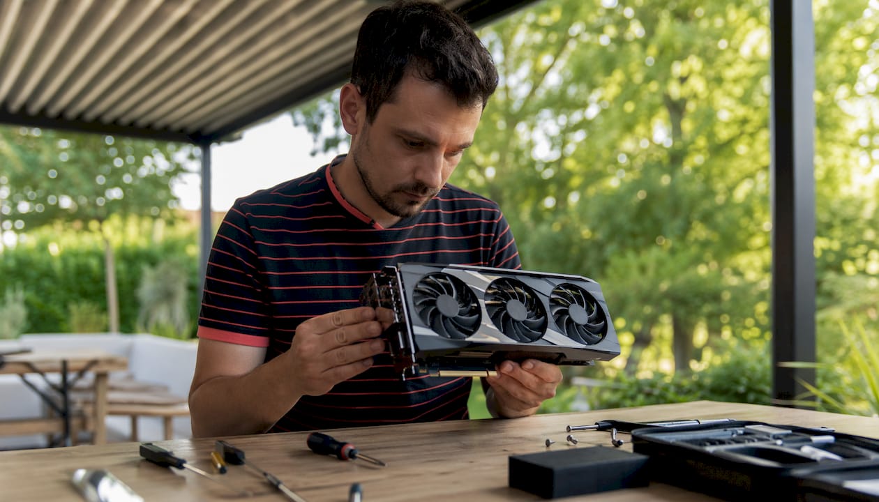 Un homme observe attentivement une barrette de mémoire vive, cherchant à vérifier son état ou son compatibilité avec son ordinateur.