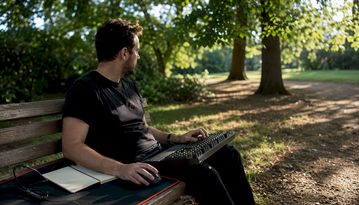 Un homme travaille au bureau en profitant d’accessoires informatiques ergonomiques pour plus de confort.