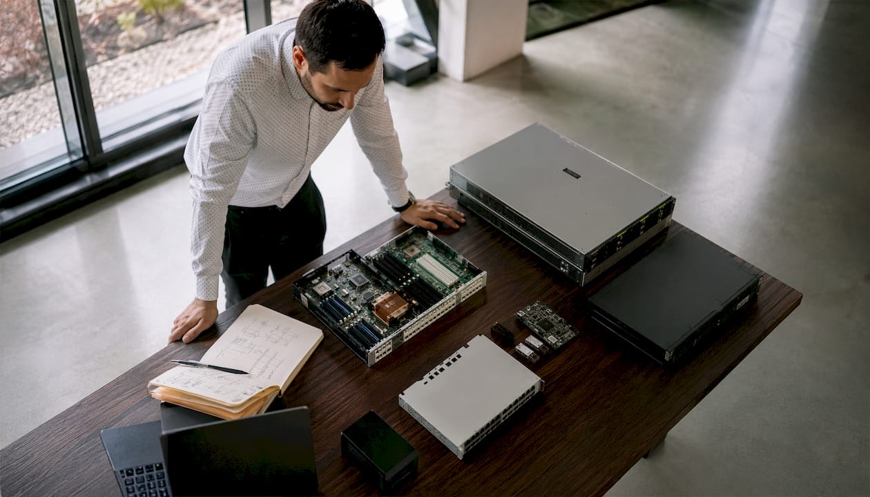 Un professionnel de l’informatique passe en revue le matériel dans une salle de réunion, s’assurant que tout fonctionne parfaitement pour les prochaines présentations.