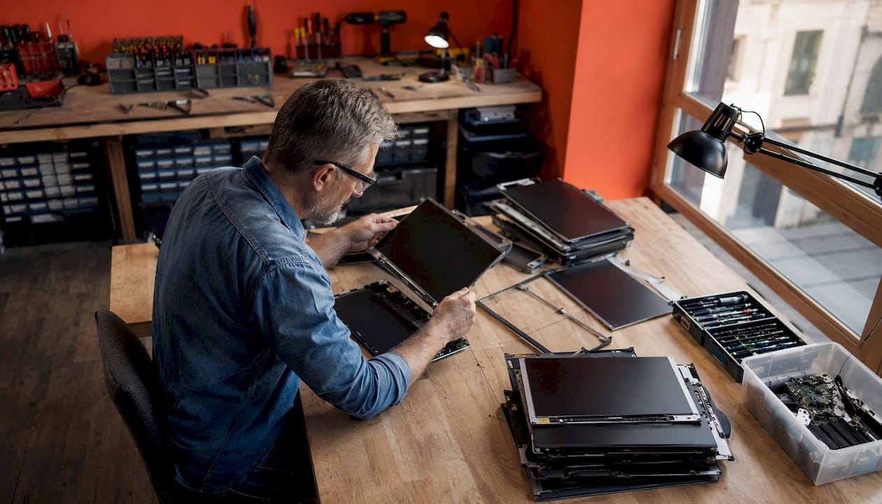 Un technicien procède au contrôle qualité des écrans d’ordinateur portable de remplacement.
