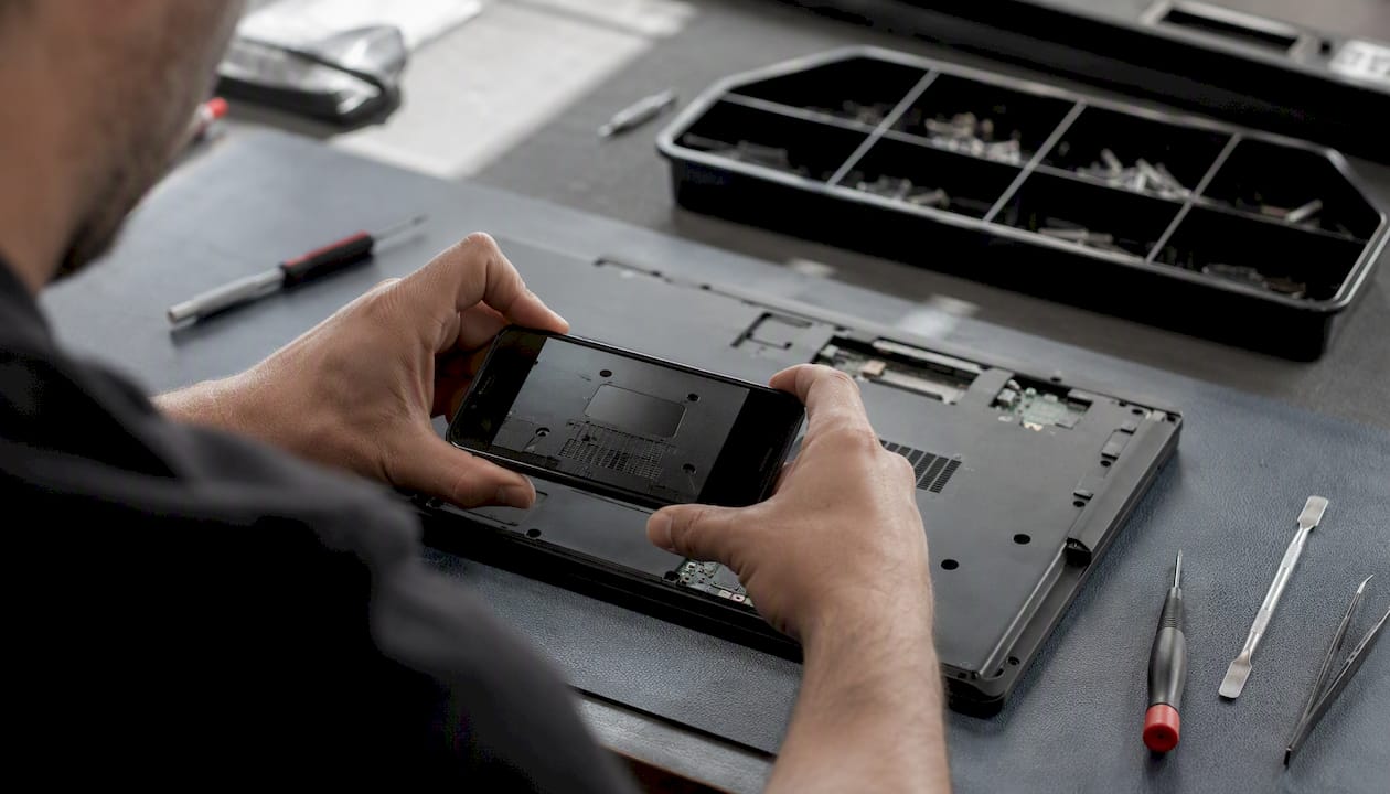 Des mains prenant en photo l’écran d’un ordinateur portable