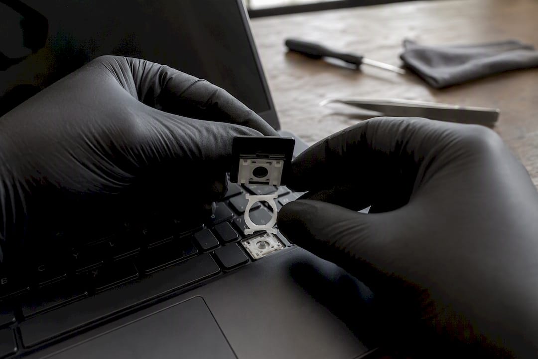 Mains installant un clip de maintien de touche d'ordinateur portable